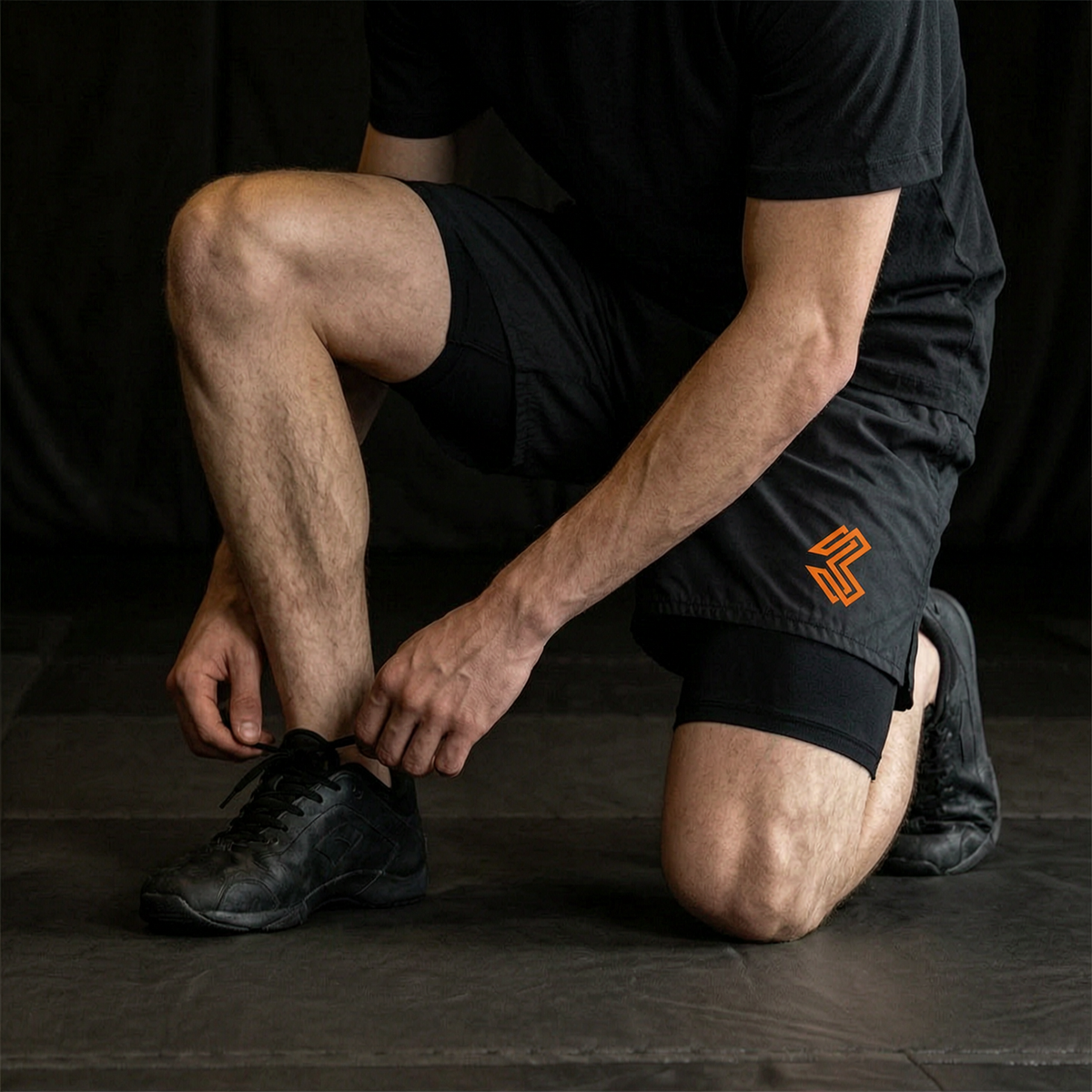 Liga Combat Rounds Liner Shorts worn under training shorts kneeling at the edge of the mat