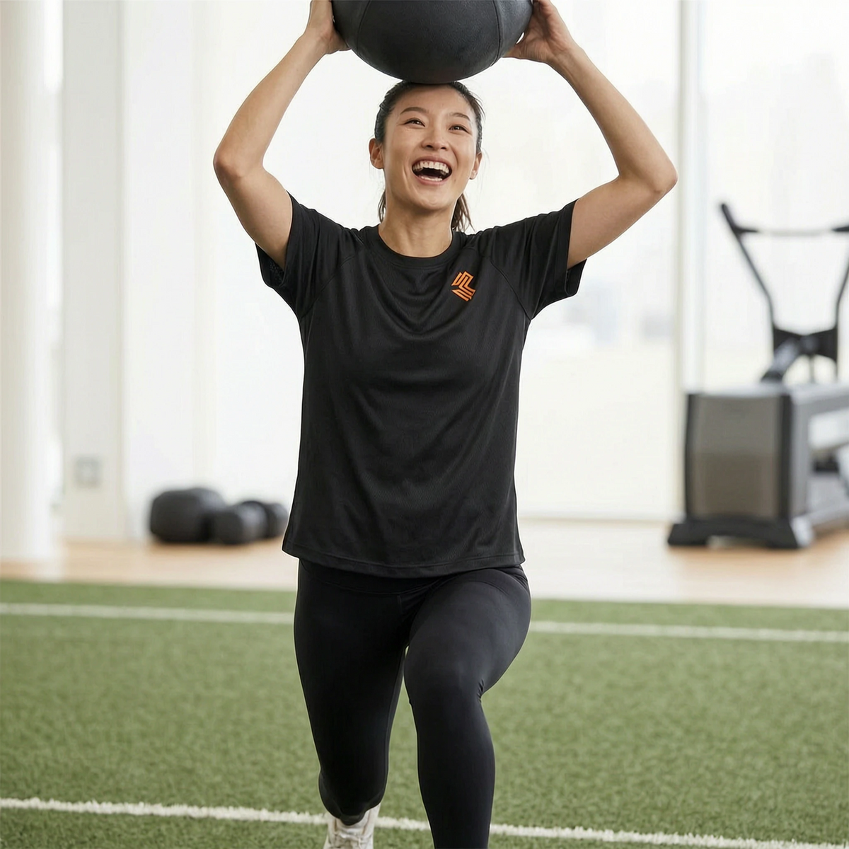 Liga Combat Rounds Mesh Tee in black, worn mid overhead lunge with a medicine ball in a conditioning session