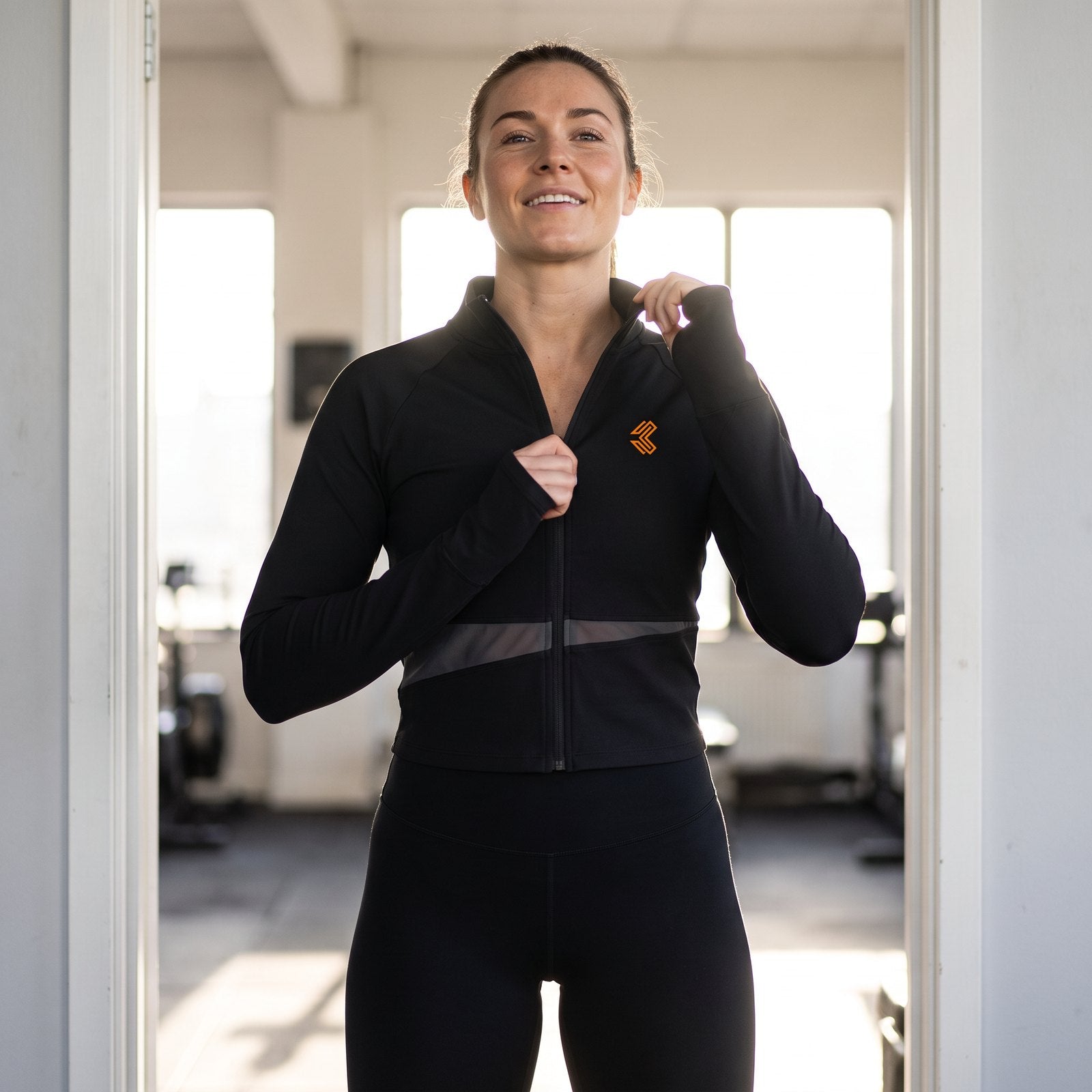 Liga Combat Between Rounds Jacket worn zipped in the gym doorway, stand collar and mesh panel