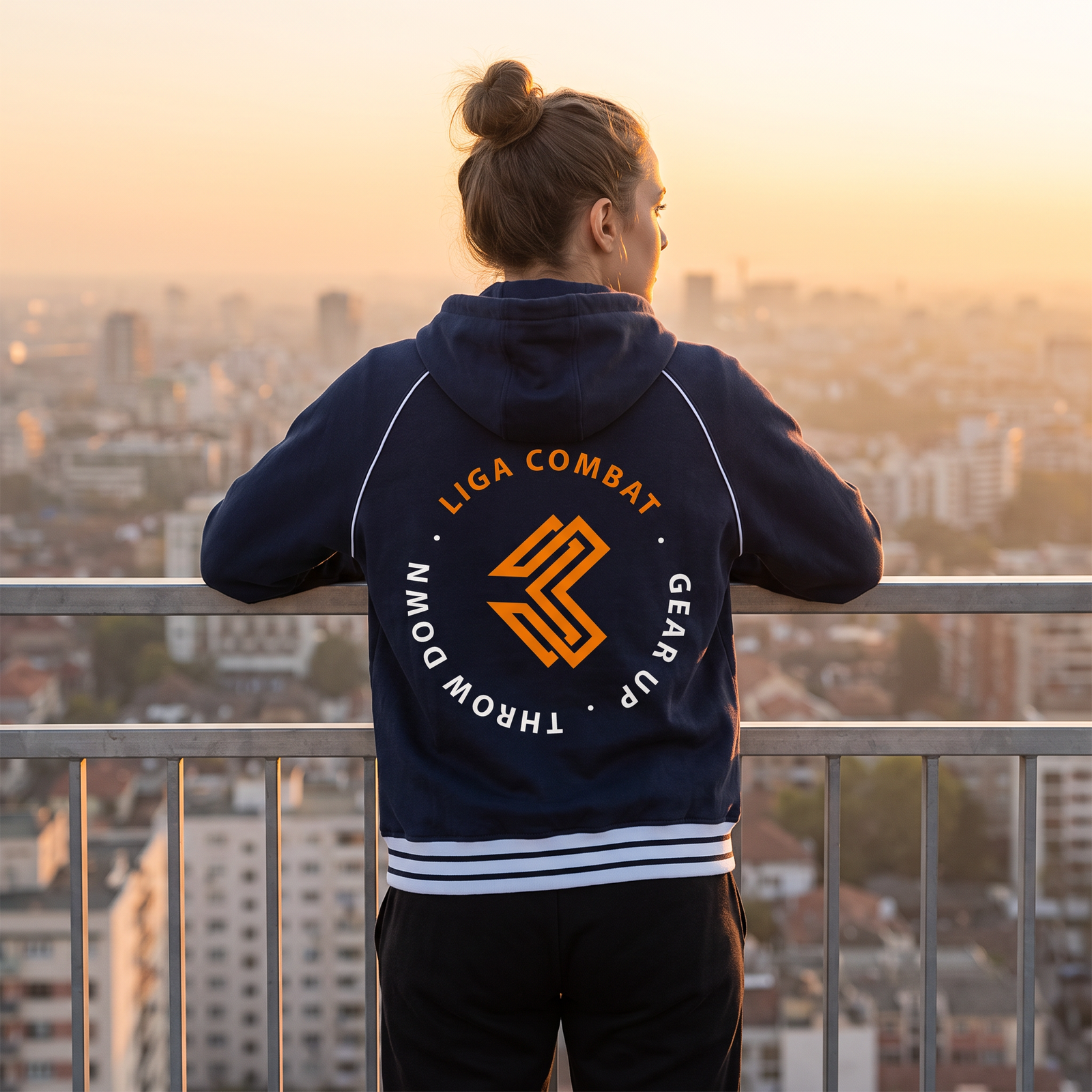 Liga Combat Varsity Mantra Jacket in navy blue from behind on a rooftop at sunset, back crest