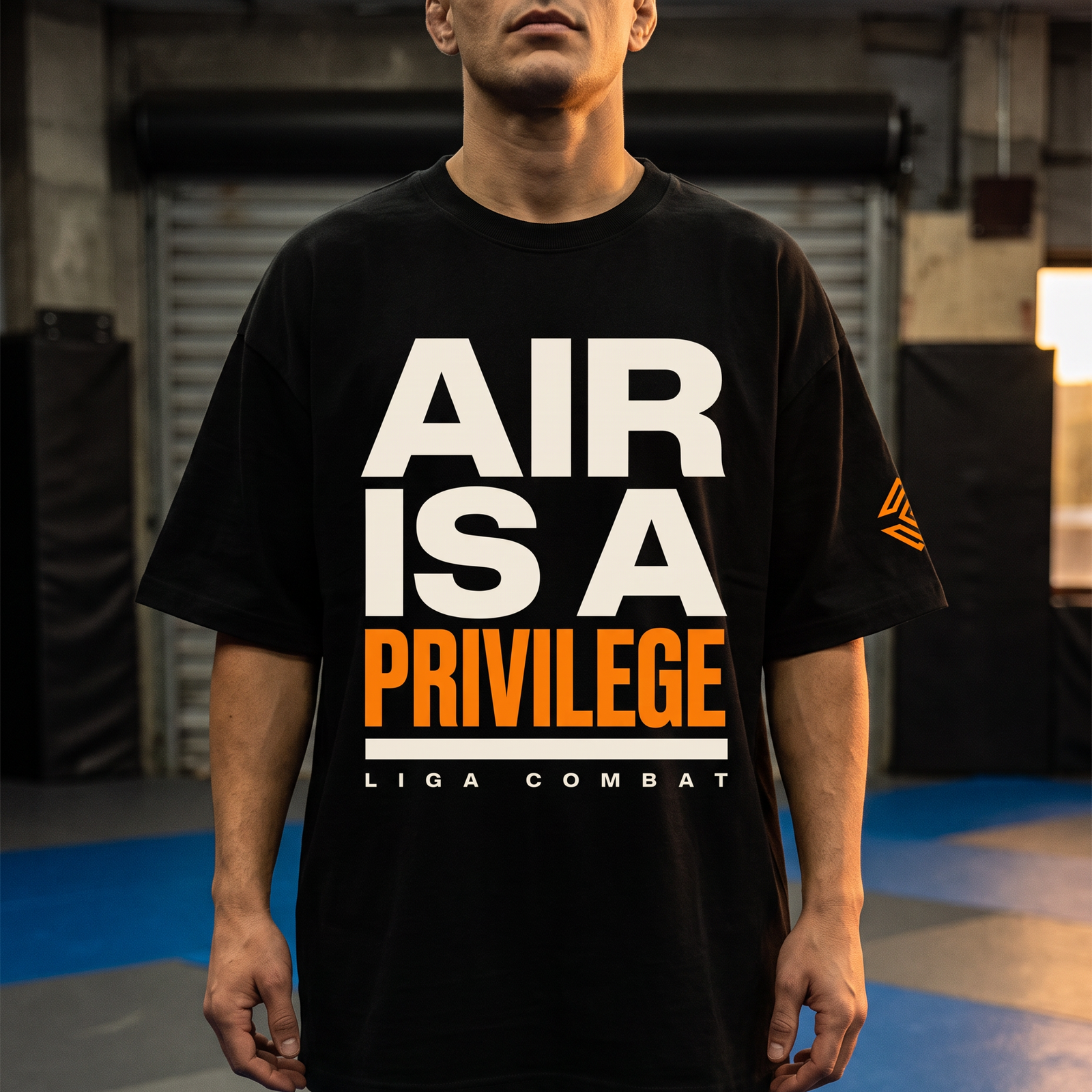 Liga Combat Air Is A Privilege Tee worn front-on in the gym, full cream and orange chest print visible