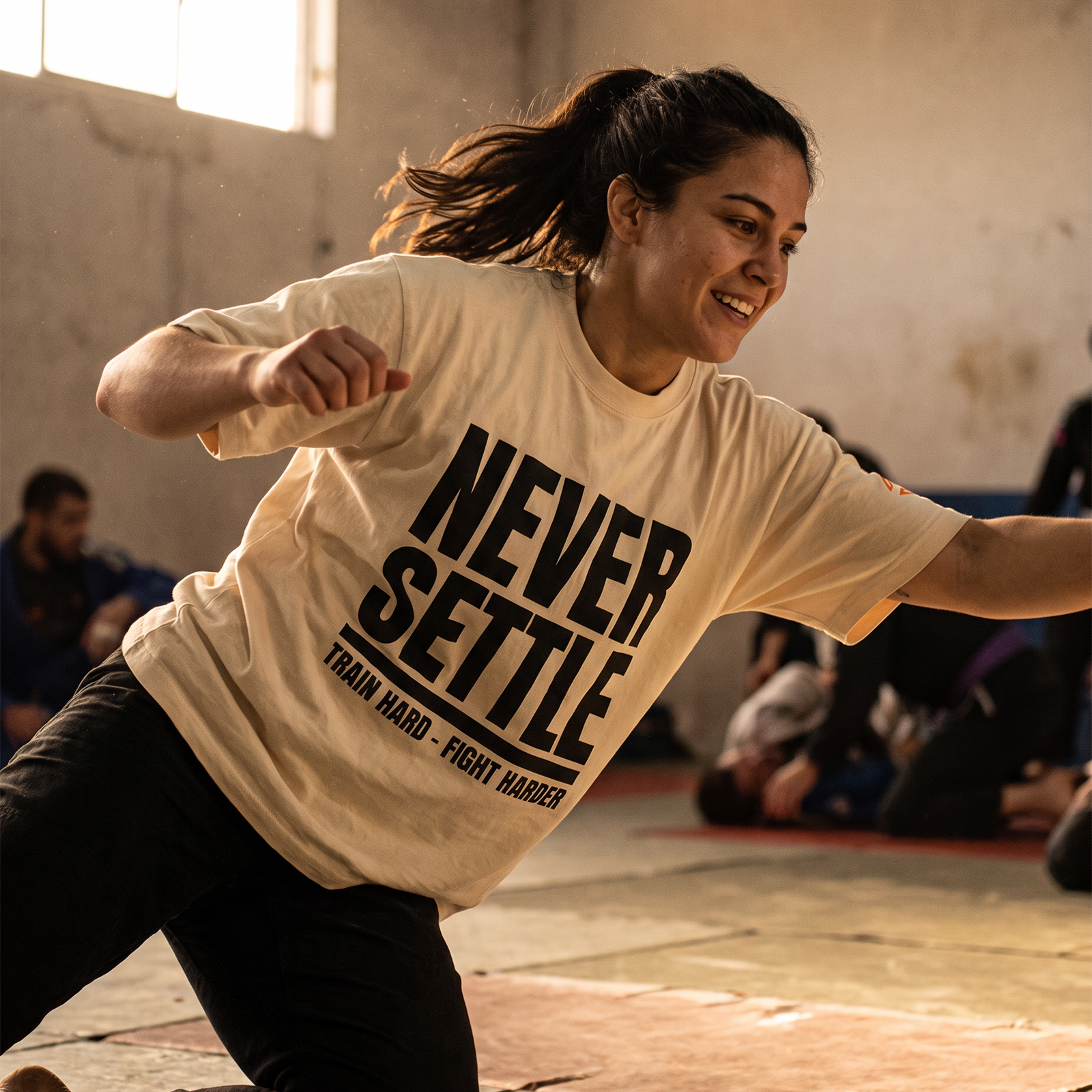 Woman in the Liga Combat Never Settle Tee driving forward mid-drill on the mats