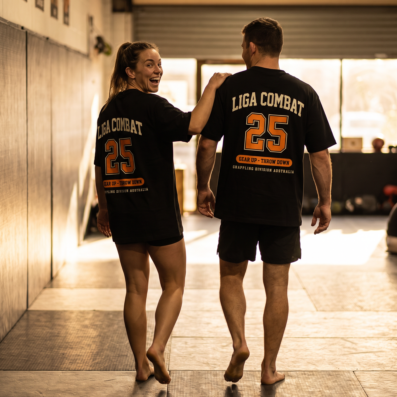 Two grapplers in Liga Combat Varsity 25 Tees walking onto the mats together before training