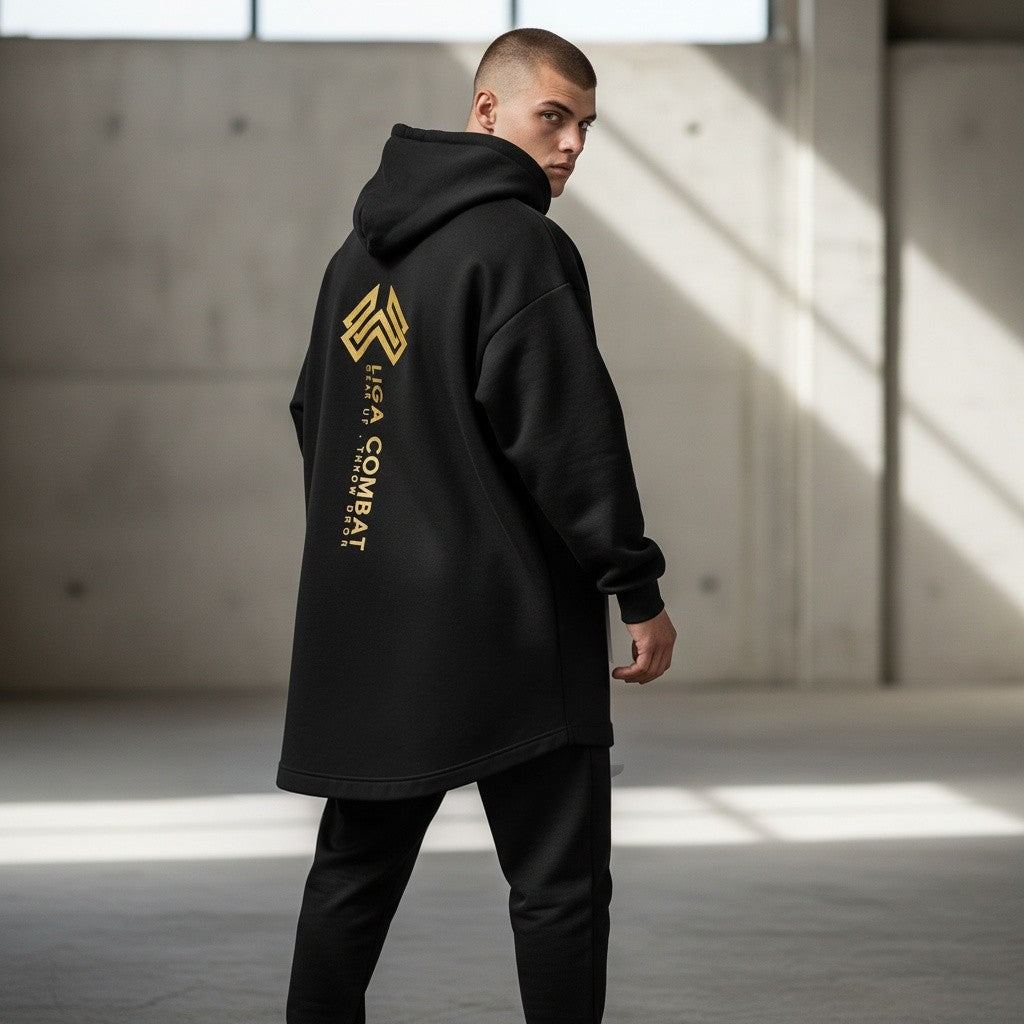 Liga Combat Throwdown Emblem black hoodie with gold back graphic worn by a man in an industrial setting