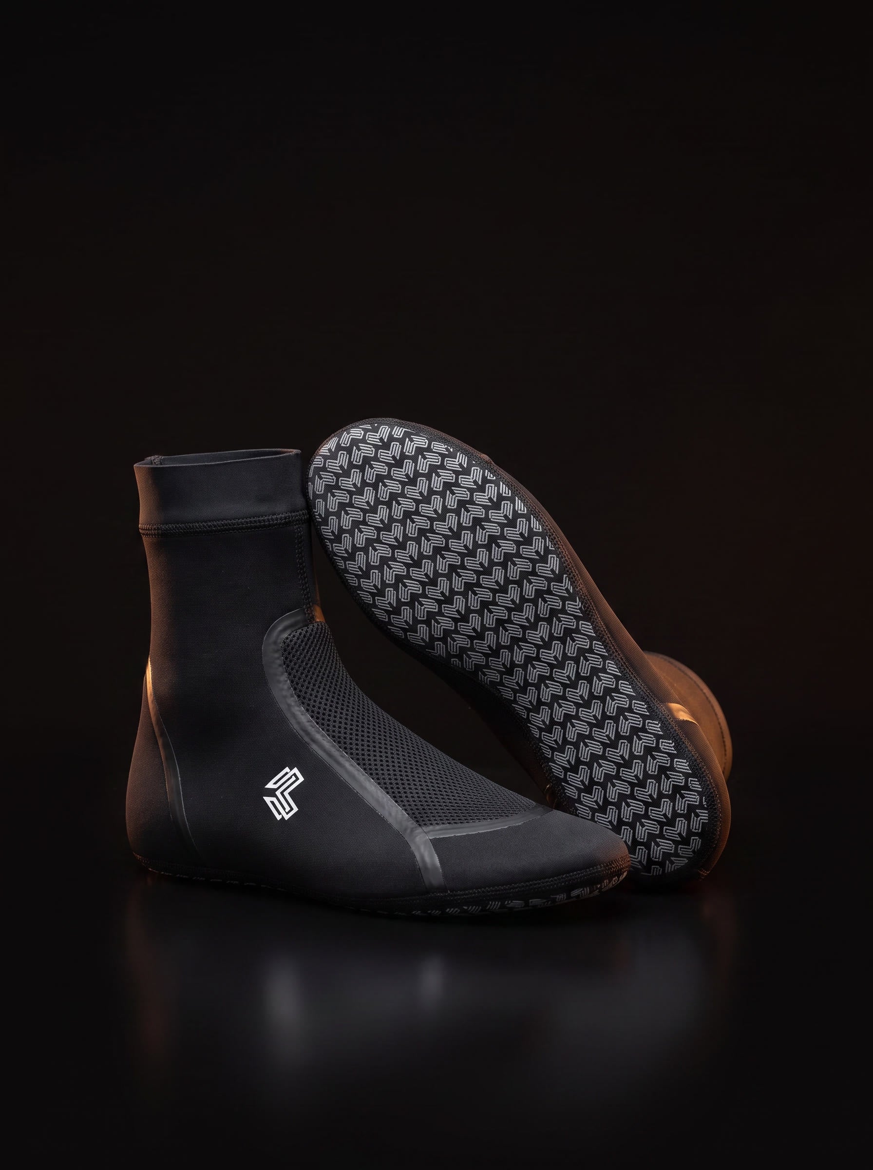 A pair of Liga Combat grappling socks on a dark studio background, one showing the chevron sole